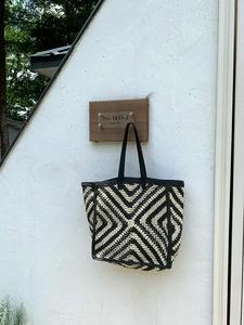 Detail of hand-crocheted tote bag with black and yellow geometric diamond patterns