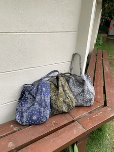 Detailed view of three vintage bandana canvas tote bags in blue, olive, and grey colors