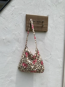 Detail of leopard print tote bag featuring pink bow pattern and durable cotton fabric