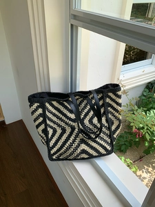Detail of the woven chevron pattern in black and beige with black leather strap