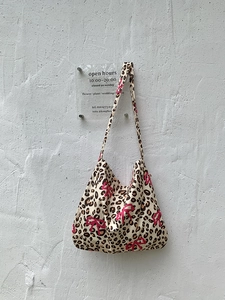 Detail shot of leopard print canvas tote bag featuring bright pink bow patterns