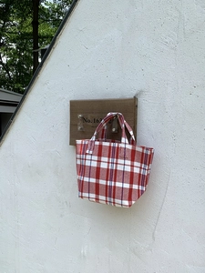 Detail shot of the red and white striped woven canvas tote bag hanging on a white wall