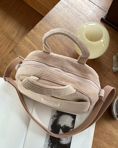 Detailed texture of corduroy mini bowling bag with a stylish woven shoulder strap
