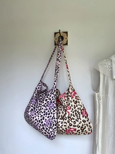 Detail view of leopard print tote bags with star and bow patterns hanging on a wall