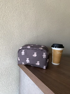 Close-up of a quilted coffee-brown cosmetic bag with cute white bear patterns and zipper