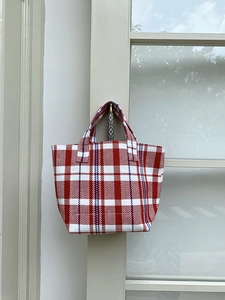 Red and white striped woven canvas tote bag hanging on a minimalist wood hook