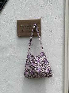 Detail of pink leopard print canvas tote bag with purple star patterns and wide strap