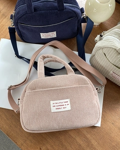 Close-up of corduroy shoulder bags showing textured fabric and adjustable woven straps