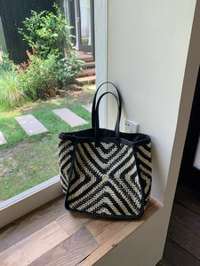 Detailed close-up of geometric crochet pattern on tote bag with leather handles