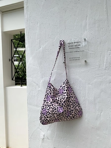 Detail of pink leopard print tote bag with star patterns and wide canvas strap