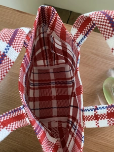 Top view of the spacious interior of a red, white, and blue striped woven canvas tote bag