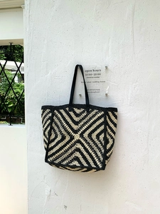 Close-up of geometric black and beige crochet tote bag with premium leather straps