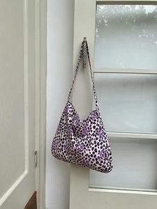 Detailed view of leopard print tote bag with star patterns hanging on a door handle