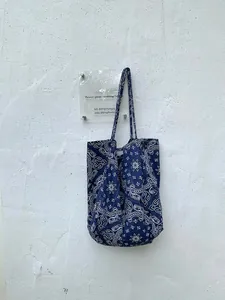 Detail showing high-quality dark blue canvas tote bag with white paisley pattern