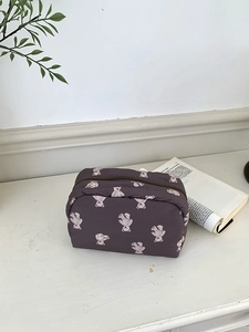 Detail of cute purple makeup bag featuring all-over white bear print and zipper closure