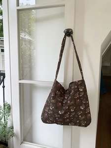 Detail of a large capacity brown cotton tote bag with vintage floral print on a door