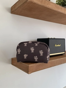 Detail of cute bear pattern makeup bag stored on a shelf next to vintage speaker
