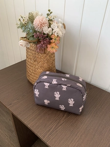 Close-up of purple nylon pouch with cute pink bear patterns on a wooden surface