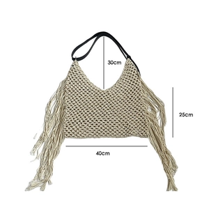 Detail of bohemian cream crochet tote bag featuring long tassels and fringe accents