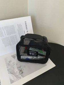 Close-up of black mesh travel toiletry bag showing breathable texture and top handle