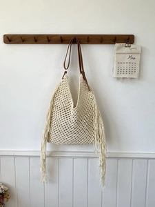 Beige crochet hollow tote bag with long fringe and brown leather straps for summer
