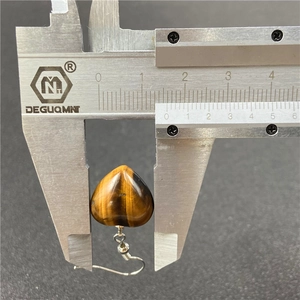 Macro shot of tiger eye heart earring measuring 1.5cm with silver hook