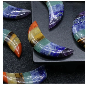 Detailed view of polished crescent moon stone crafted with colorful seven chakra crystals