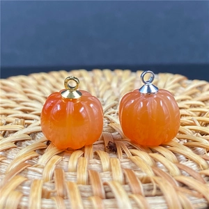 Dettaglio di ciondoli a forma di zucca con ganci dorati e argentati per gioielli fai da te