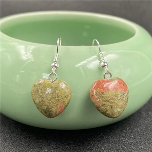 Macro detail of unakite heart earrings with unique red and green natural stone textures