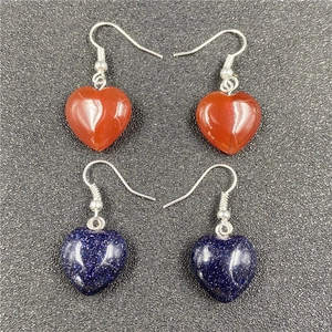 Detail of heart-shaped stone earrings in deep red and starry blue sand finish