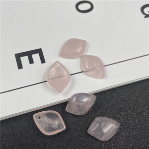 Detailed view of polished rhombus-shaped pink quartz beads for DIY jewelry making