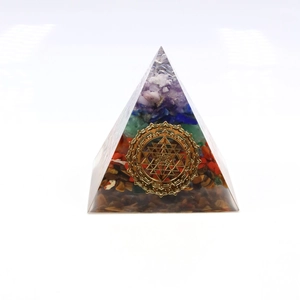 Macro view of Orgone pyramid with layered natural gemstones and golden Sri Yantra symbol
