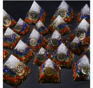Macro view showing layered chakra natural stones and gold symbols in orgone pyramid