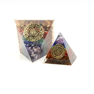 Two Orgonite pyramids with natural healing crystals and golden Sri Yantra symbols