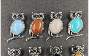 Detailed grid view of vintage owl brooches with colorful gemstone inlay on silver alloy