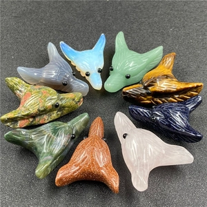 Detailed view of nine carved wolf head pendants in various natural gemstones and quartz