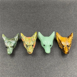 Macro detail of hand-carved natural fox head charms in tiger eye and quartz
