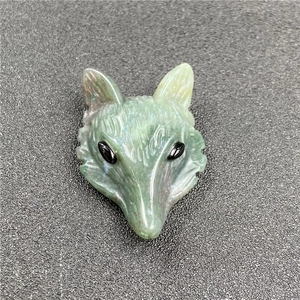 Detailed view of fox head pendant hand-carved from green natural gemstone with black eyes