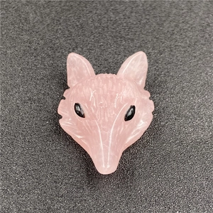 Macro shot of hand-carved rose quartz fox head pendant with natural stone textures