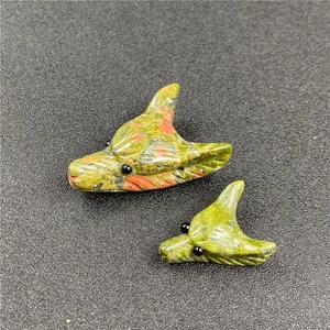 Macro detail of hand-carved stone wolf head pendants in various natural mineral textures