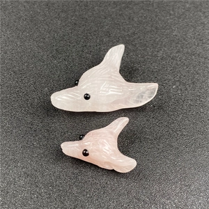 Close-up of hand-carved rose quartz fox head pendants in small and large sizes