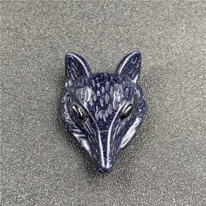 Macro shot of blue sandstone fox pendant with detailed carving and sparkling finish