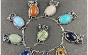 Macro shot of vintage owl brooches with various colorful natural stone cabochons