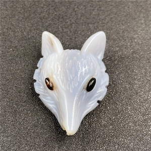 Macro detail of hand-carved light blue fox head gemstone pendant with fine textures