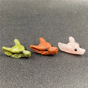 Detail showing carved fox heads in pink quartz and green stone with polished finish