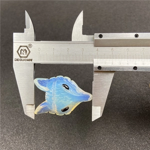 Macro shot of a blue opal wolf head pendant measured by calipers showing 40mm size