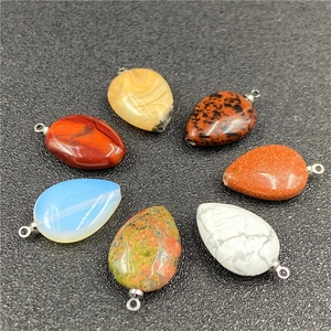 Detailed view of teardrop crystal pendants with silver loops in various gemstones