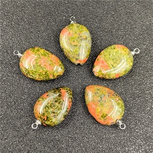 Macro detail of five unakite teardrop pendants with polished green and orange patterns