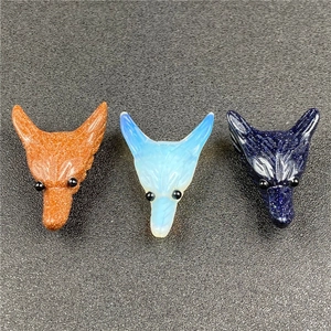 Wolf head carved gemstone pendants in rose quartz, tiger eye, and gray agate materials