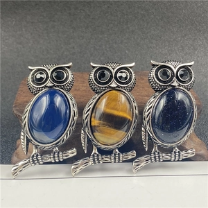 Vintage owl brooch with natural gemstones and silver alloy feathers on wood display